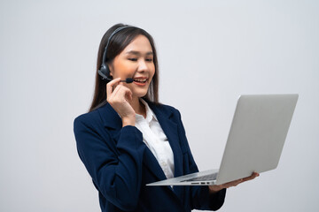 Beautiful Asian call center operator talking with customer using laptop isolated on grey background.