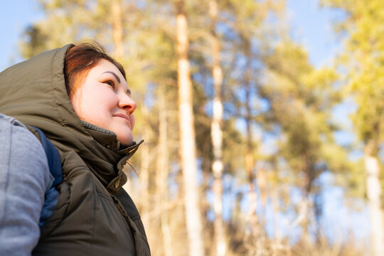Side view photo of calm woman warm dressed in the forest enjoying the nature for feeling free and spend wonderful day.