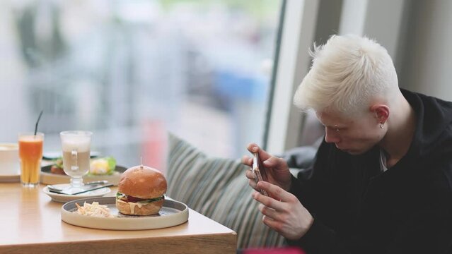 Man Taking Mobile Pictures of Burger with vegetables salad. Social Media Lifestyle