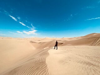 Fototapeta na wymiar A man standing in the middle of the desert in Peru