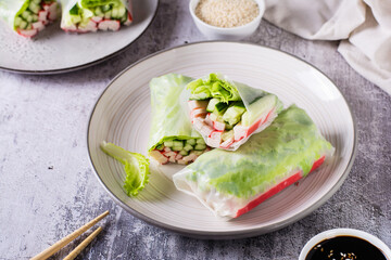 Fresh spring rolls with crab sticks, cucumber and lettuce. Vegetarian food.