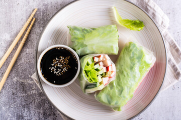 Fresh spring rolls with crab sticks, cucumber and lettuce. Vegetarian food. Top view. Closeup