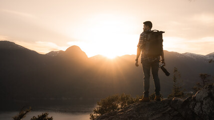 man standing on top of mountain during sunset
