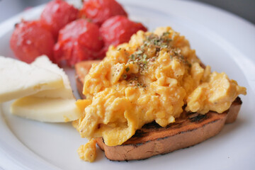 morning breakfast with Scrambled eggs on a bread on white plate 