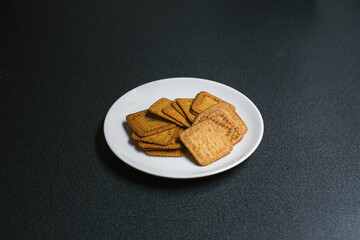 Homemade thin crispy crackers on white plate, Selective Focus.