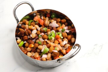 High in protein boiled black chana or chickpea salad. Chopped tomatoes, onion, chilies, and coriander mixed with boiled peanuts or Bengal gram. Weight loss meal. Served with Lemon. Copy space.
