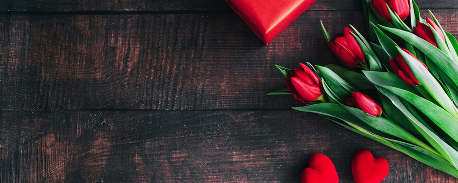 Bouquet of red tulips on a wooden background. Spring flowers. Mother's Day background.Horizontal wide photo subtitle, cover. copy-space - Powered by Adobe