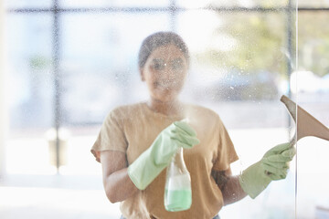 Happy, woman and cleaning window with smile, spray bottle and soap or detergent housekeeping in...