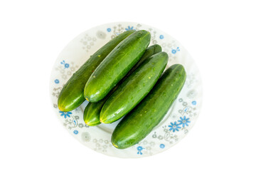 Fresh cucumbers on a plate on white isolated background