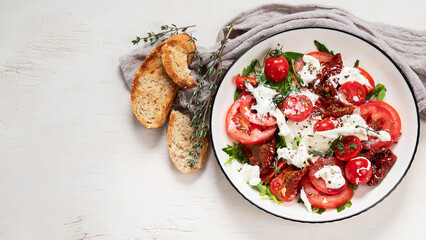 Delicious caprese salad with tomatoes and mozzarella cheese with fresh leaves. Italian food.