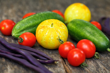 Homegrown fresh vegetables harvested from an organic kitchen garden, including cherry tomatoes, pole beans and cucumbers