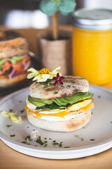 Whole wheat toasted bread with avocado, poached egg, pea sprouts and cheese over white background. Top view. Healthy diet
