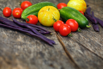 Homegrown fresh vegetables harvested from an organic kitchen garden, including cherry tomatoes, pole beans and cucumbers