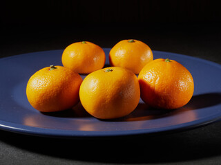 one orange mandarin on blue plate