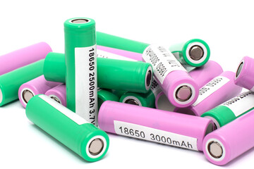 A lot of li-on batteries with inscriptions about capacity, current and voltage lie in a pile...