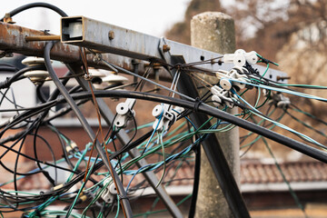Numerous wires tangled in complexity on a telephone pole.