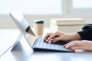ノートパソコンでネットサーフィンをするアジア人女性