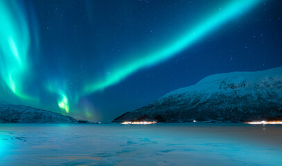 Fototapeta na wymiar Northern lights or Aurora borealis in the sky over Tromso fjords - Tromso, Norway
