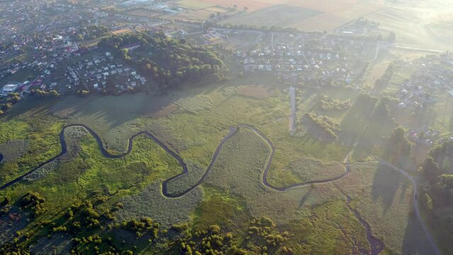 4k drone flying over footage (Ultra High Definition) of flooded valley. Misty morning scene of snake shape Seret river. Spectacular sunrise on Ternopil countryside, Ukraine, Europe.