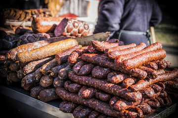 An outdoor stall with a bunch of homemade sausages for sale
