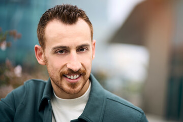 Portrait of smiling confident man posing to camera at business district