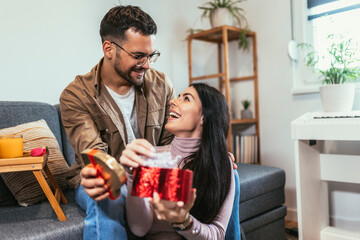 Man giving a surprise gift to woman at home