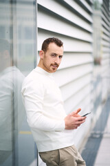 Young handsome man holding smartphone using mobile app shopping online