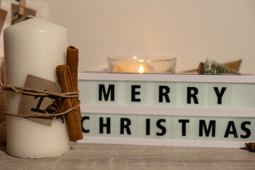 Candles with advent calendar Lightbox with text MERRY CHRISTMAS Traditional Burning Christmas Wax Candles with numbers counting down for Christmas. Beautiful Advent At Home. Festive Candlelight