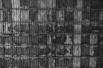 Black and white Old metal roofing materials that have been damaged by time