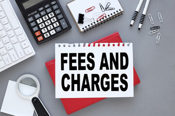FEES CHARGED - gray background with white keyboard and text on paper. Business concept