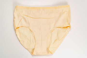 a yellow cotton panties on a white background. the concept of classic underwear made of natural...