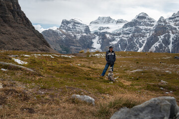 Tourist in front of stacked rocks, valley of Ten Peaks track. Alberta, Canada.