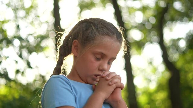 child pray. young gratitude a god religion concept. little girl in nature outdoors praying dreams of happiness to lifestyle god. praise worship freedom concept. kid praying in the forest