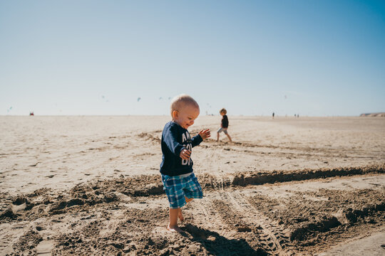 Young boy running happy at kiters beach in Fuerteventura