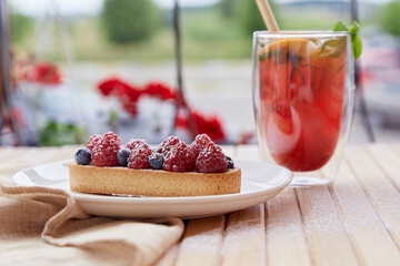 Refreshing raspberry- orange lemonade with mint and cane straw outside. Sugar free tart with...