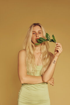 Blonde freckles woman and natural make-up holding leaves