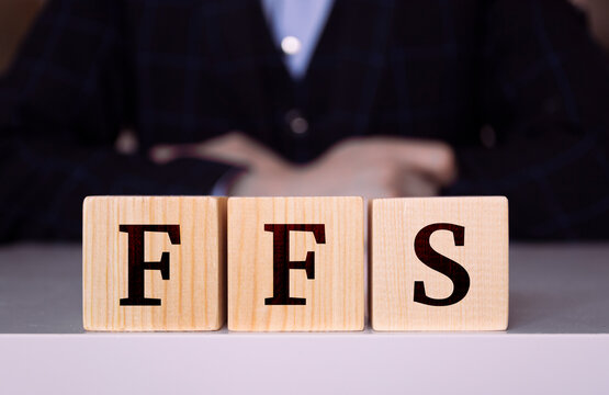 The word "FFS" written on wood cube. Business concept, Fee for services - Powered by Adobe