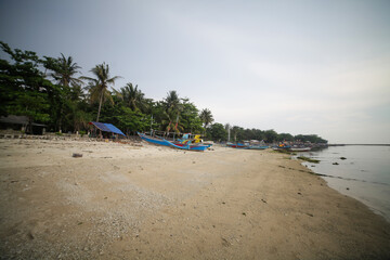 Fototapeta na wymiar beach with white sand and leaning boats, Ujung Genteng Sukabumi Indonesia
