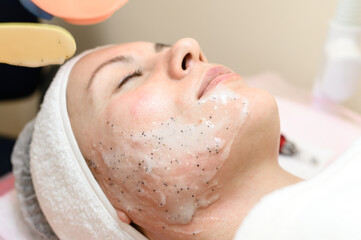 The process of applying a moisturizing mask to the face in a spa salon.