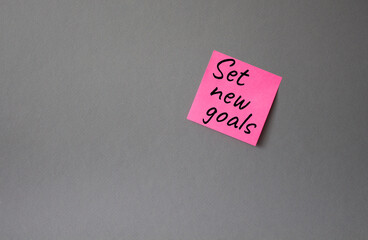 Set New Goals symbol. Concept words Set New Goals on pink steaky note. Beautiful grey background. Business and Set New Goals concept. Copy space.