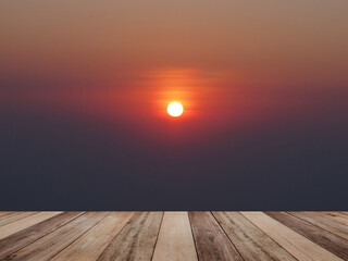 Wood table top over sun at sunset beach with blurry sky background.