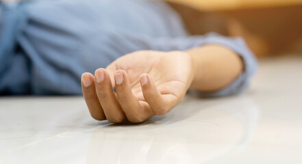 close up adult man hand lying on home's floor in living room after got fainted symptom from heart...