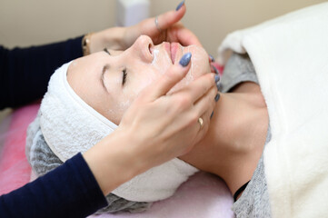 Procedure at a cosmetologist, cleansing the face of cosmetics and preparing the face for massage.