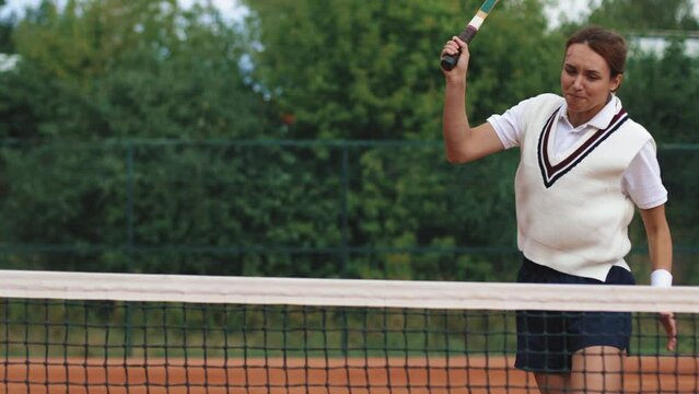 4k video. Young and beautiful sporty african american woman playing tennis in clay court. Amatour frienship match. Vintage and retro racket. Natural tree background.