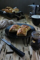 Baked cheesecake on a plate against a background of piles of bread on a wooden tray