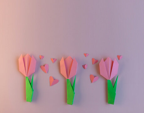 Paper pink tulips and pink hearts on a pink background. Spring decor, DIY for children, greeting card for mom. holiday concept. Banner with space for text