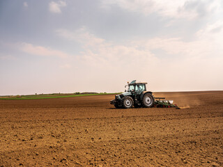 Obraz premium Agricultural worker using a tractor to plant soybean seeds