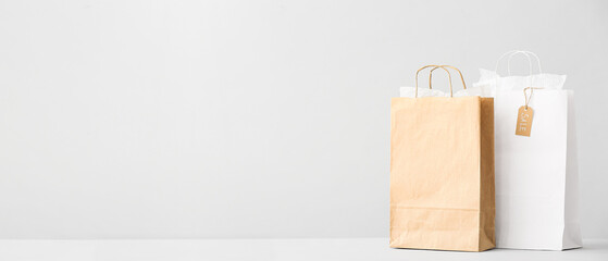 Paper shopping bags on light background with space for text