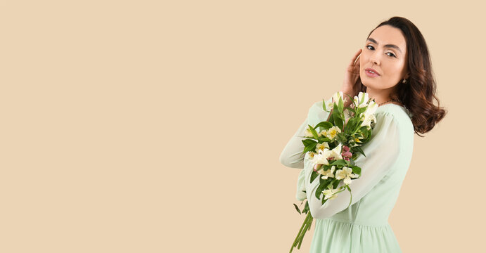 Beautiful young woman with bouquet of alstroemeria flowers on beige background with space for text