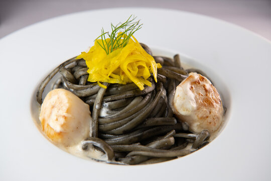 Recipe for Linguine Pasta with squid ink and scallops, yellow chioggia beet. High quality photo